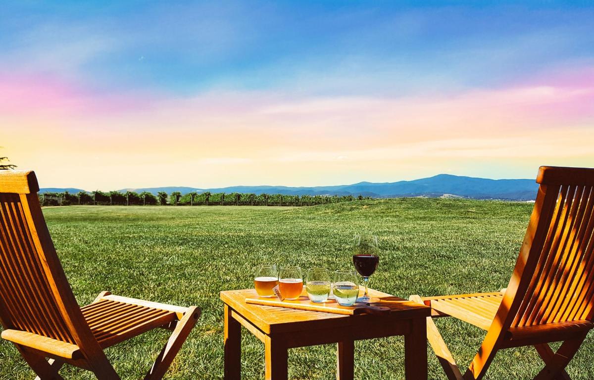 a table with a glass of wine and two chairs