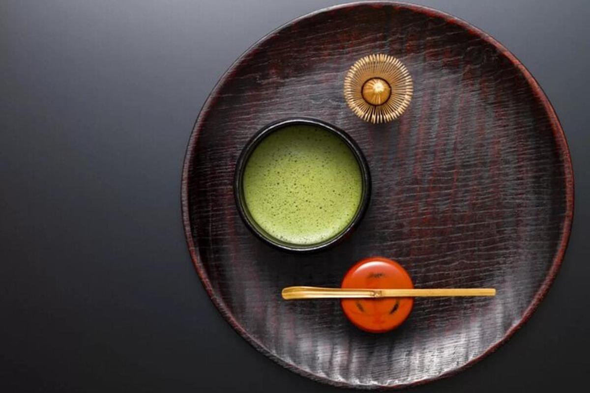 un piatto con una ciotola di liquido verde e una bacchetta