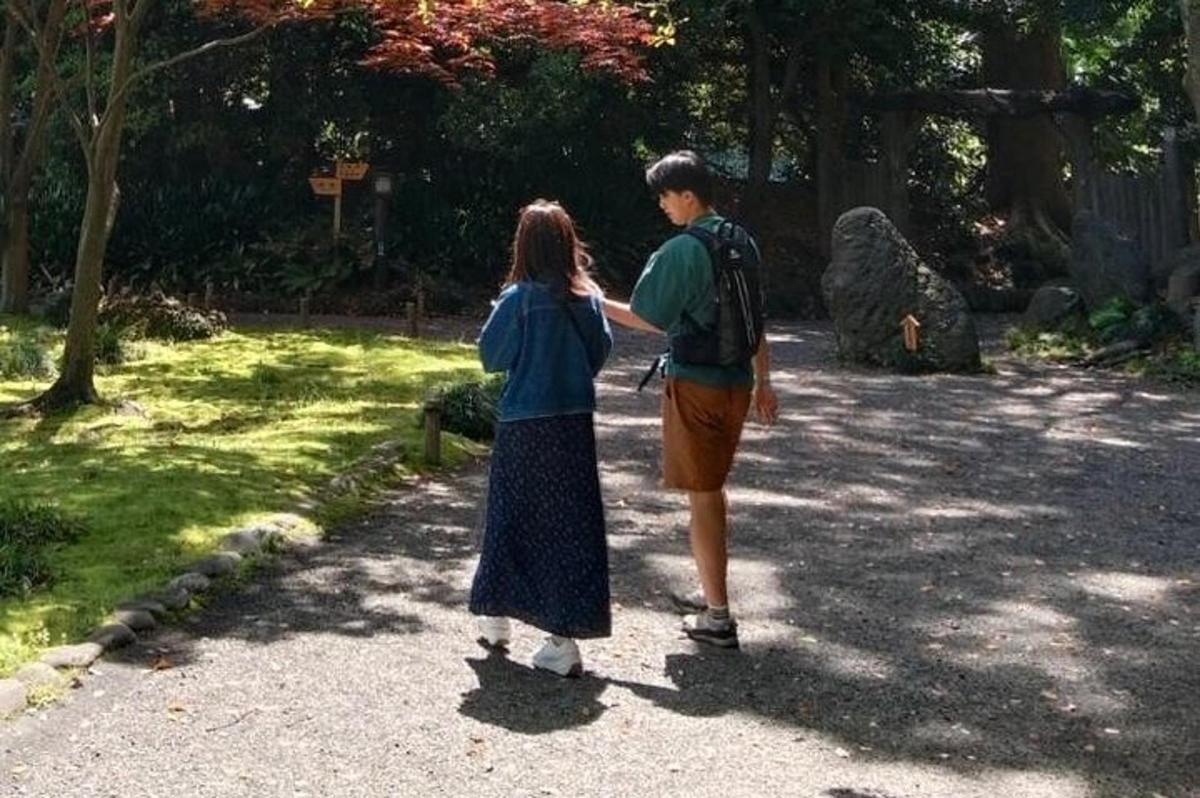 a man and a woman walking down a path