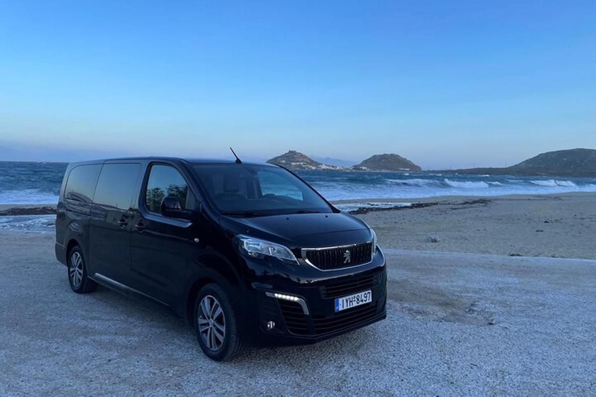 črn kombi parkiran na plaži blizu oceana