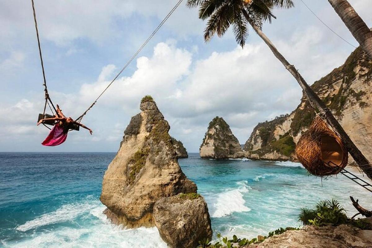osoba houpající se na lanové houpačce nad oceánem