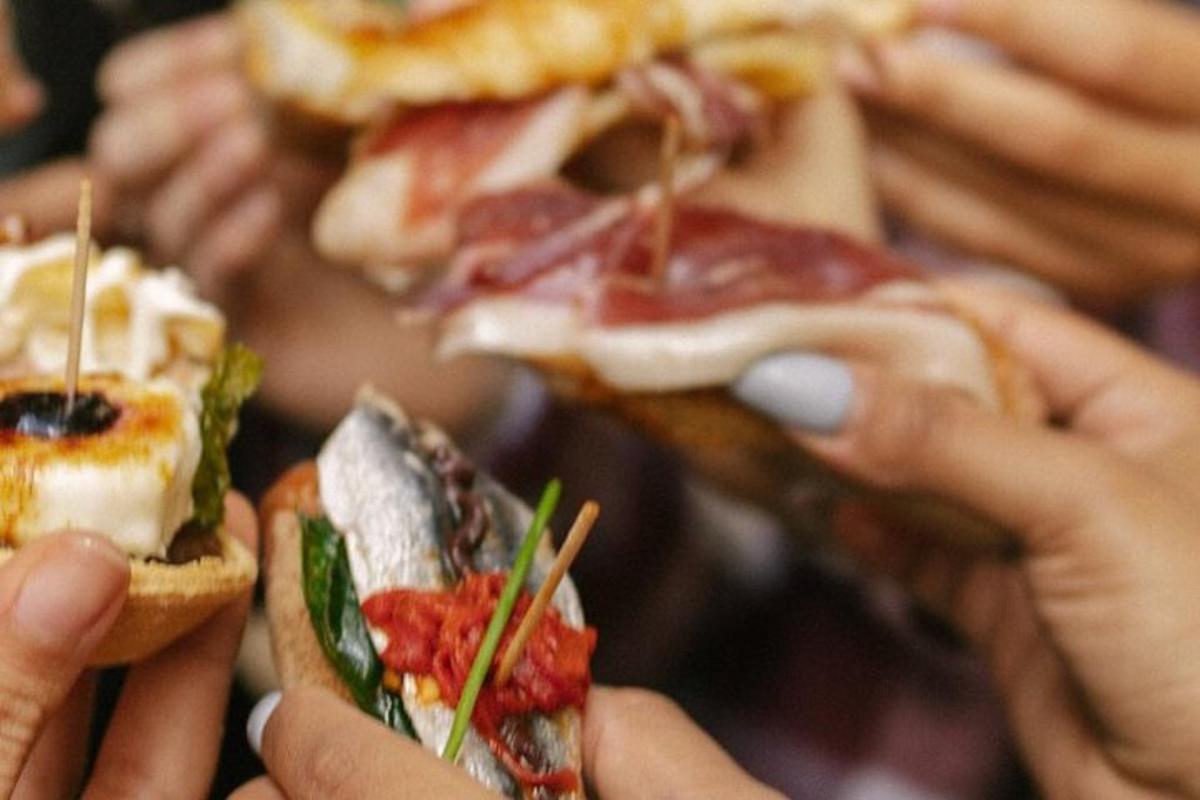 isang grupo ng mga tao na may hawak na mga sandwich na may chop sticks