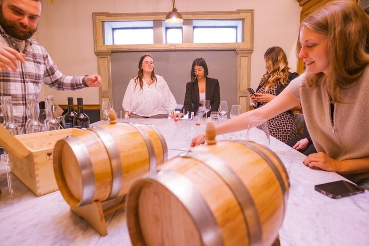 um grupo de pessoas sentadas ao redor de uma mesa com barris de vinho