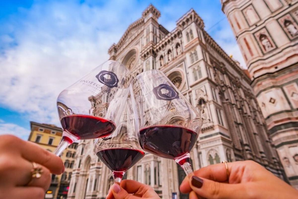 due persone che tengono in mano bicchieri di vino davanti a un edificio