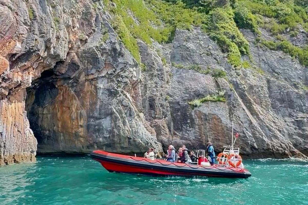 a group of people on a red boat in a cave