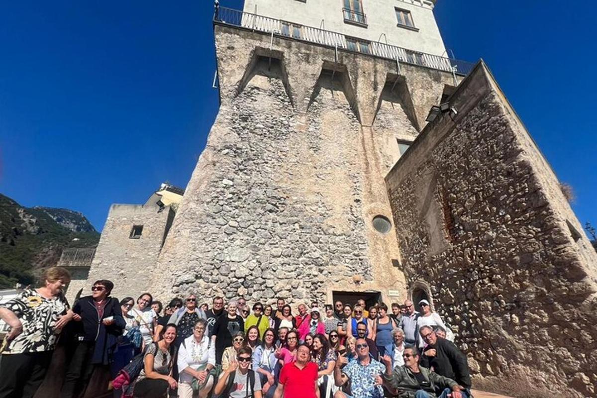 un gruppo di persone in piedi davanti a una torre