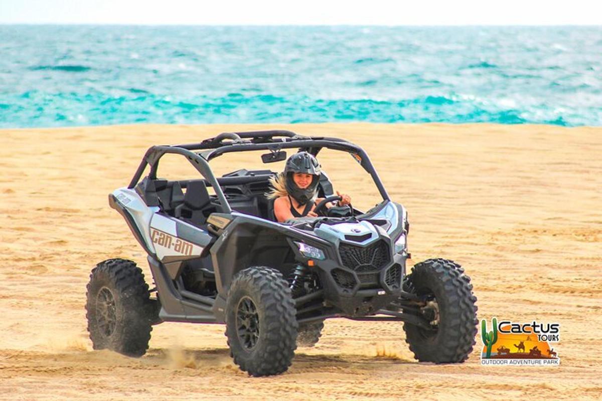 Una mujer montando un quad en la playa