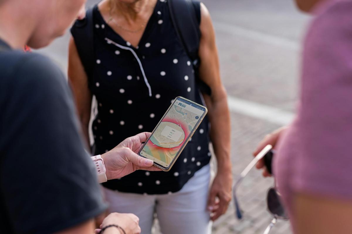 ženska, ki drži mobilni telefon v roki