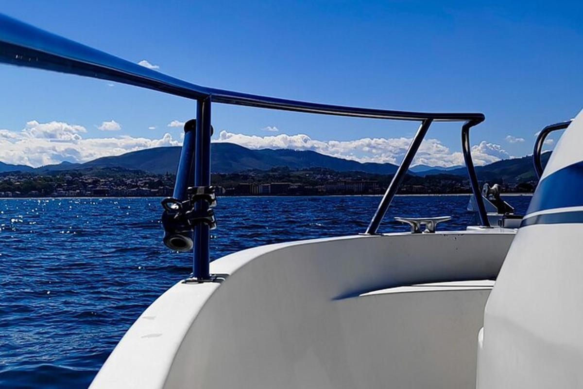 ein Boot auf dem Wasser mit Bergen im Hintergrund