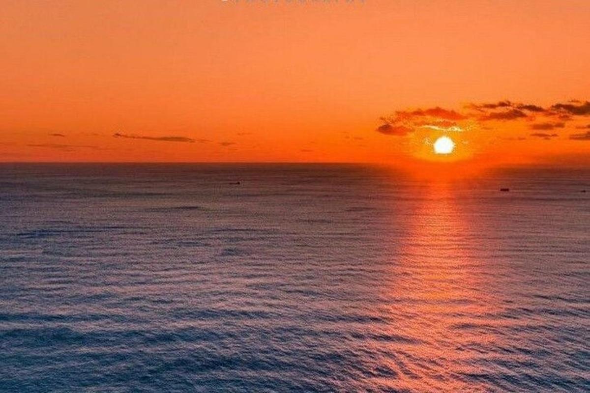 um pôr do sol sobre o oceano com o sol se pondo