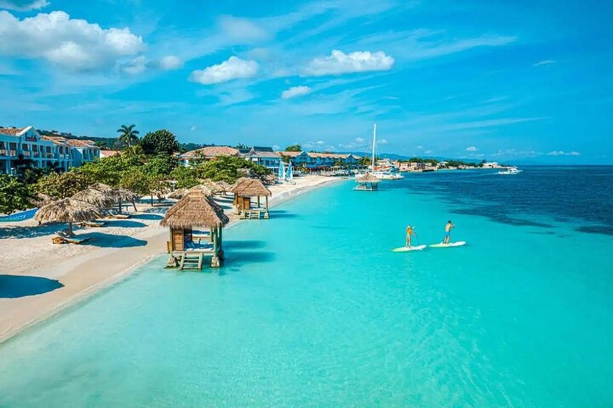 a beach with people on surfboards in the water