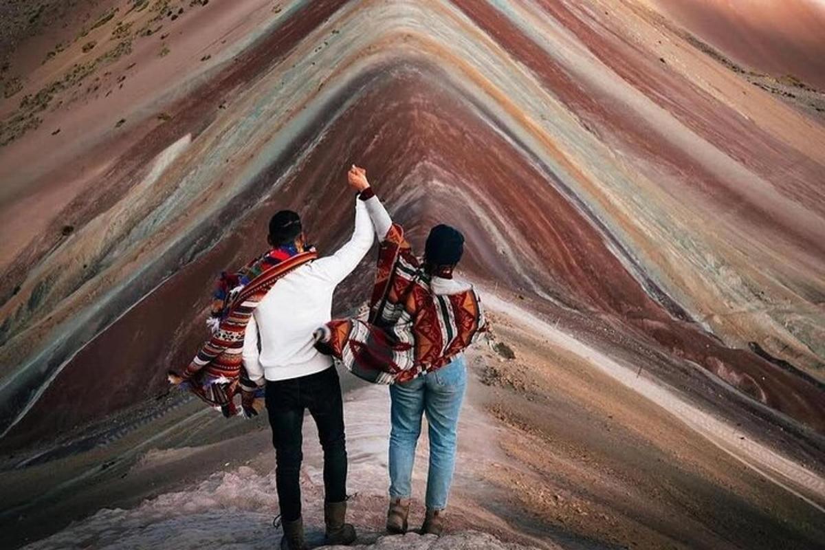 dua lelaki berdiri di atas gunung dengan tangan mereka di udara
