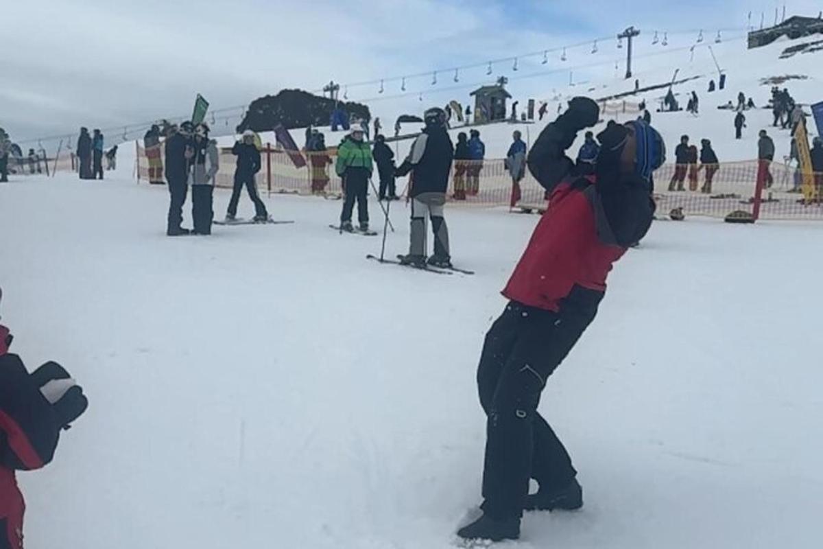 un groupe de personnes debout dans la neige sur une piste de ski