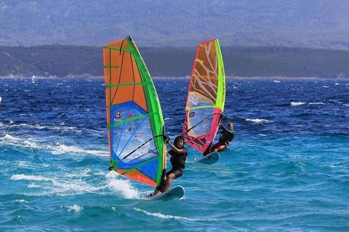 Dva lidé windsurfují v oceánu