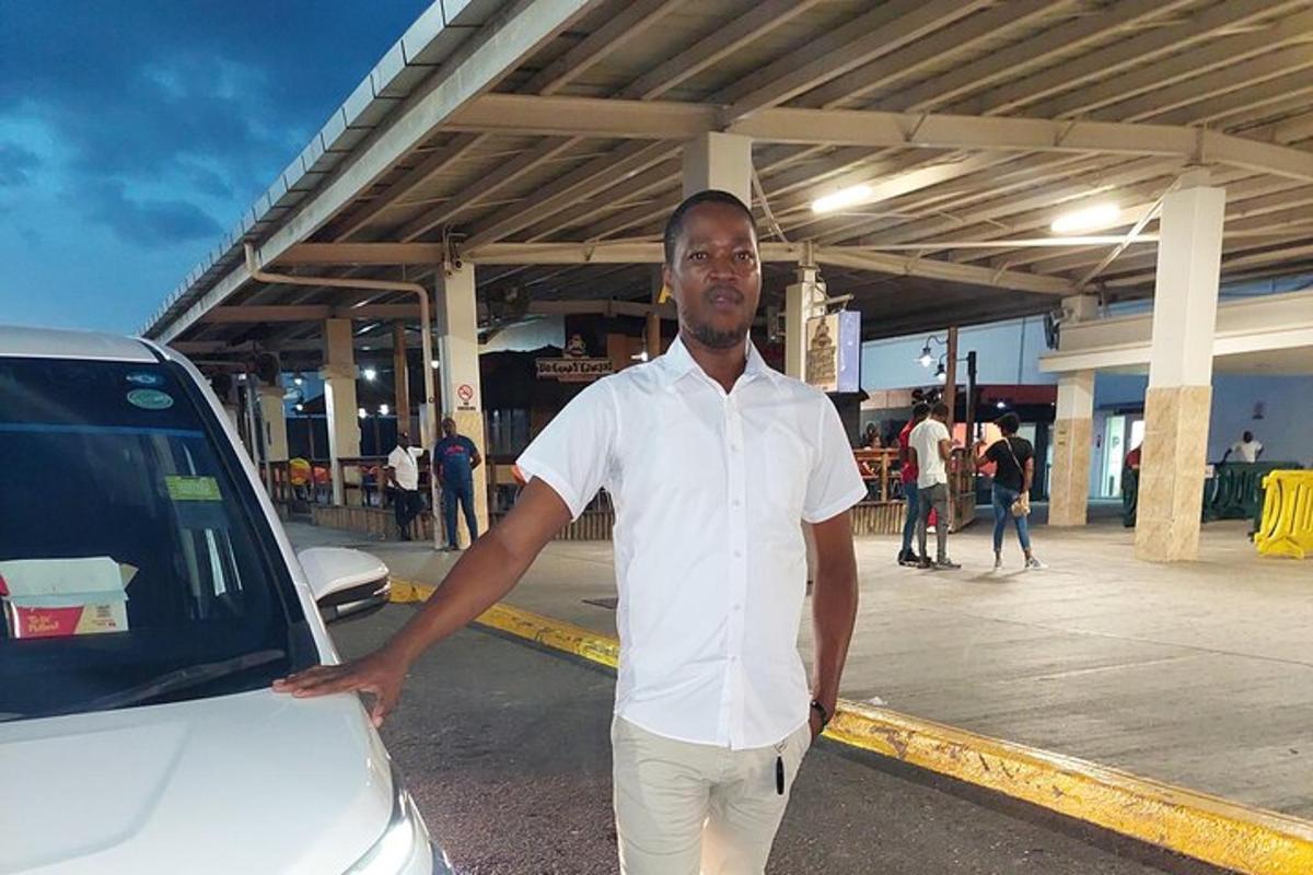 un uomo in piedi accanto a un'auto in un parcheggio