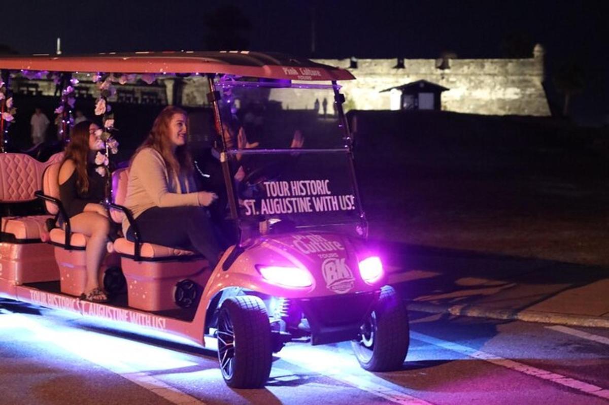 Un carrito de golf con dos personas viajando en él.