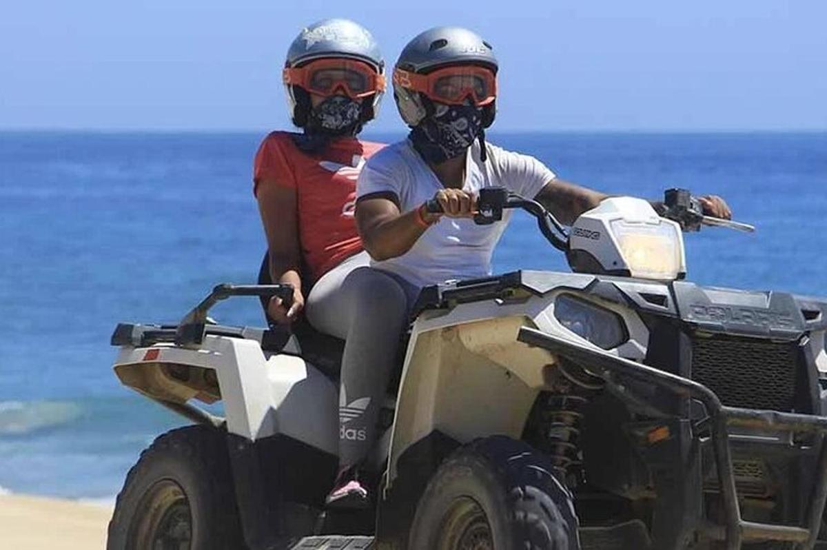 Δύο άτομα κάνουν ποδήλατο quad στην παραλία