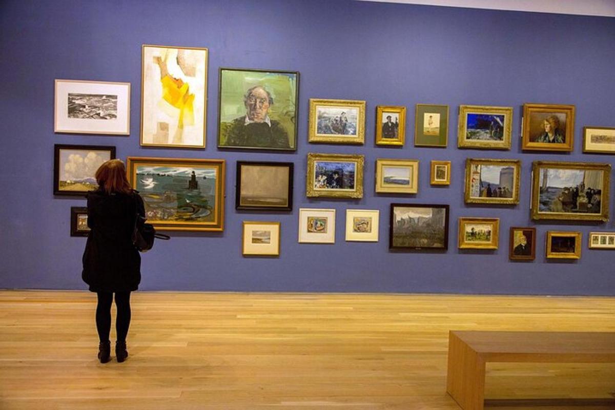 Kona skoðar vegg af myndum í safni