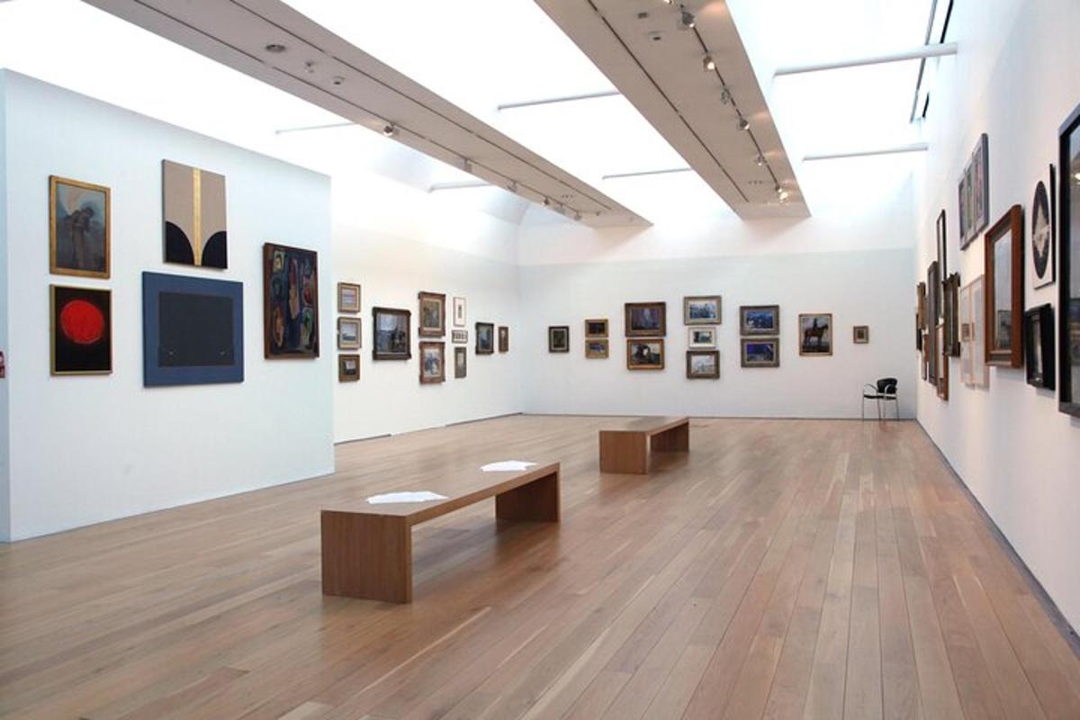 galerie s obrazy a lavičkami v místnosti