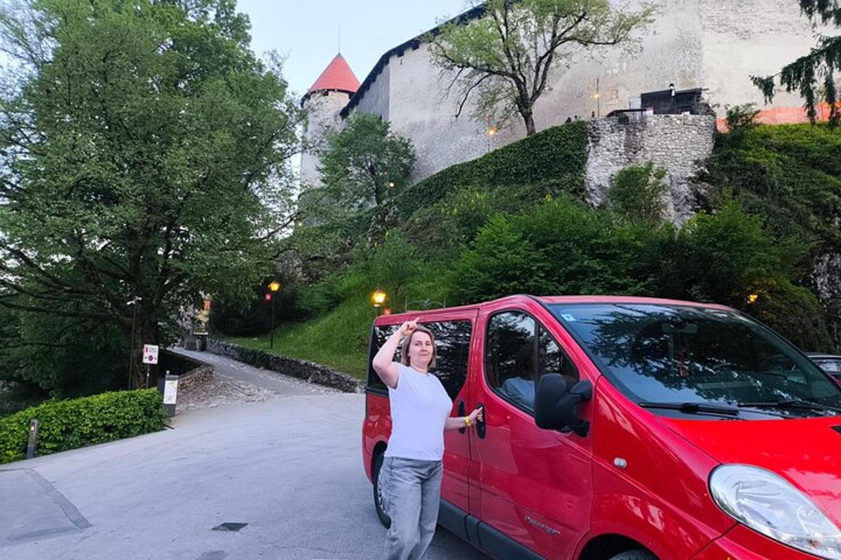 Žena stojí vedle červené dodávky
