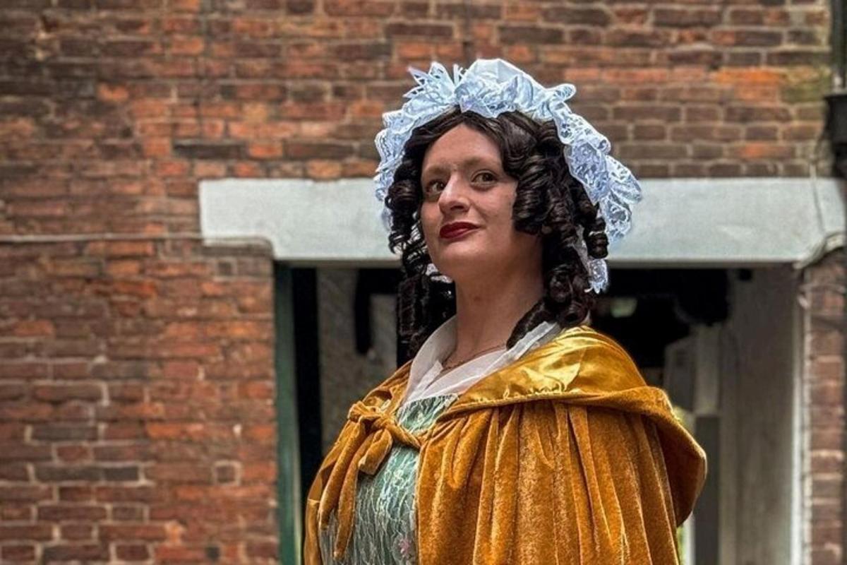 a woman dressed in a costume standing in front of a brick building