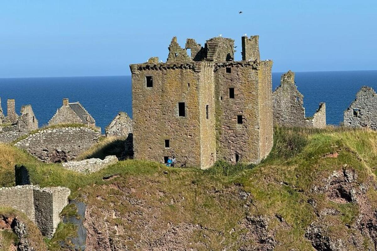 un castel vechi pe vârful unui deal lângă ocean