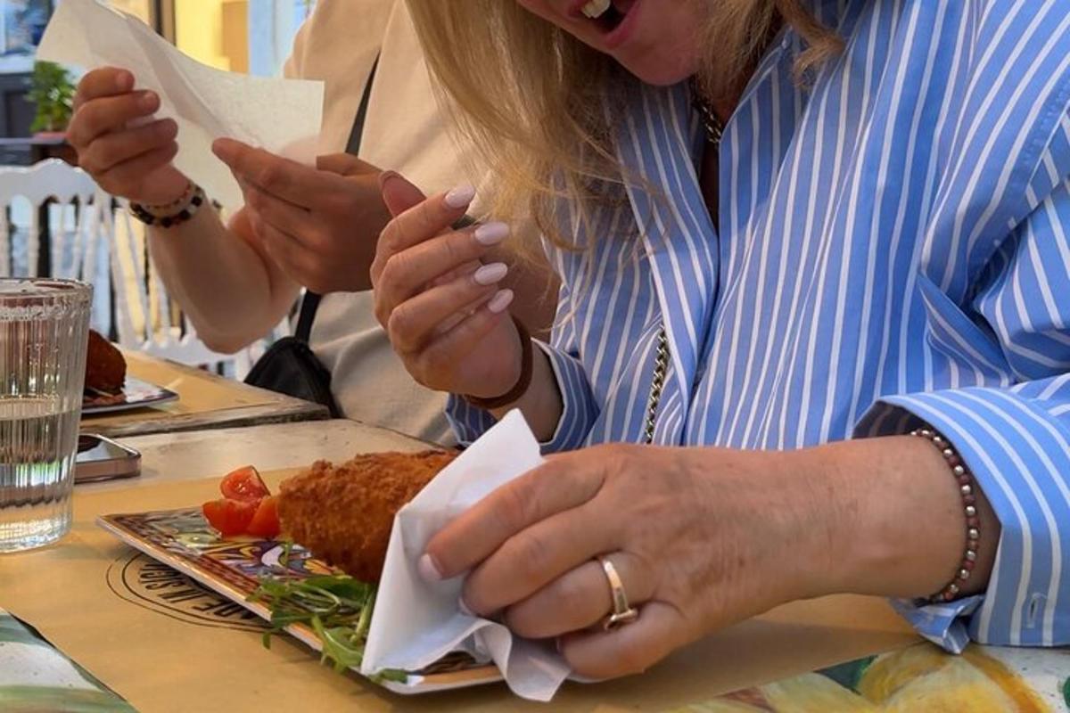 žena sedící u stolu s talířem jídla