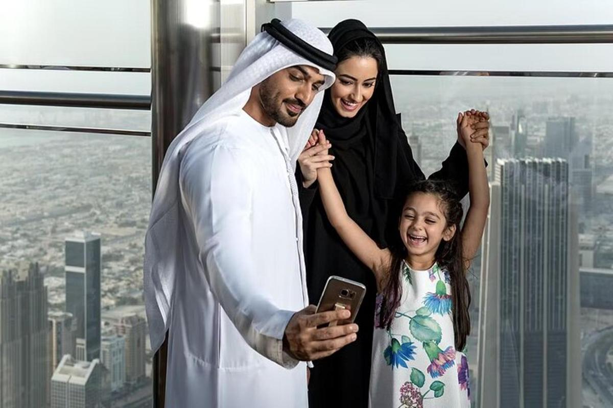 a man and a woman and a girl looking at a cell phone