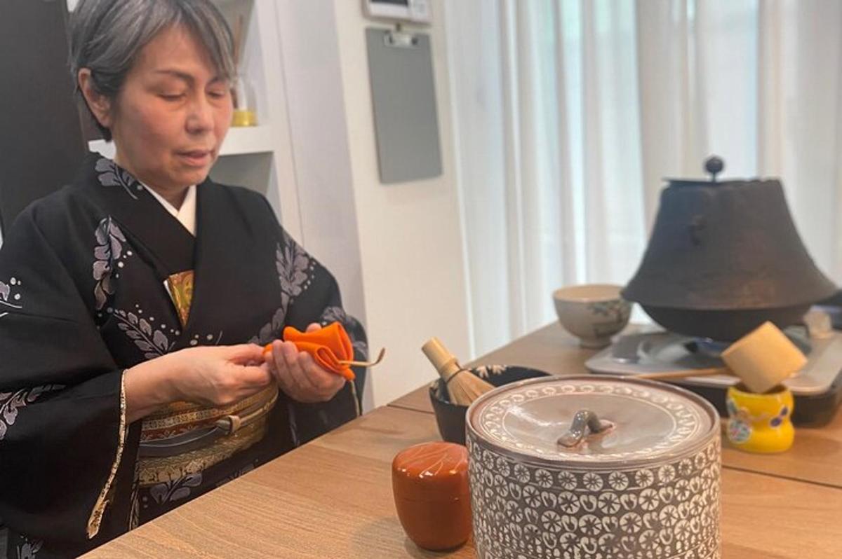 a woman sitting at a table holding a carrot