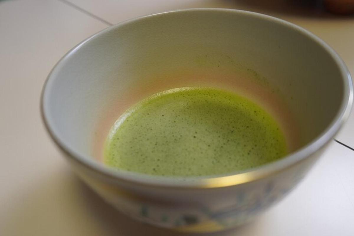 a bowl of green liquid sitting on a counter