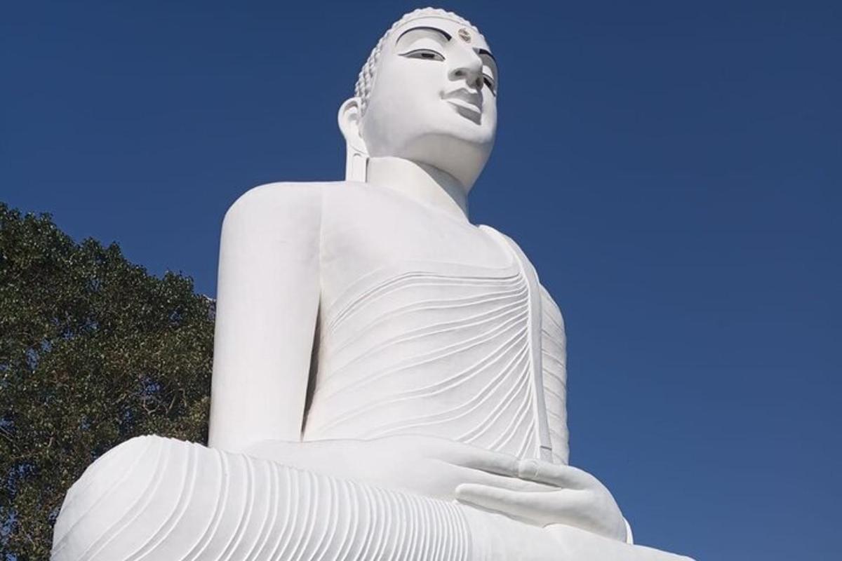 una grande statua bianca di una donna seduta a terra