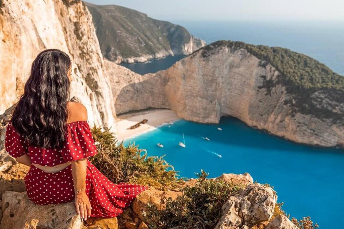 Μια γυναίκα που κάθεται σε έναν γκρεμό κοιτάζοντας τον ωκεανό