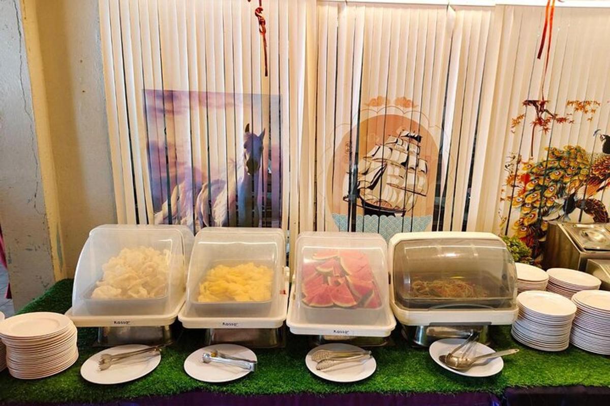 isang mesa na may apat na plastik na lalagyan ng pagkain at mga plato