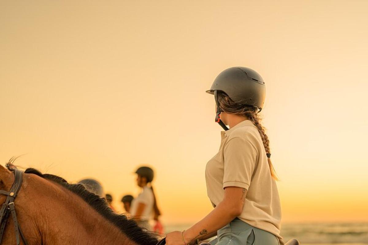 una donna a cavallo sulla spiaggia
