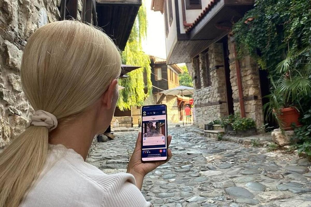 a woman taking a picture of a street with her cell phone