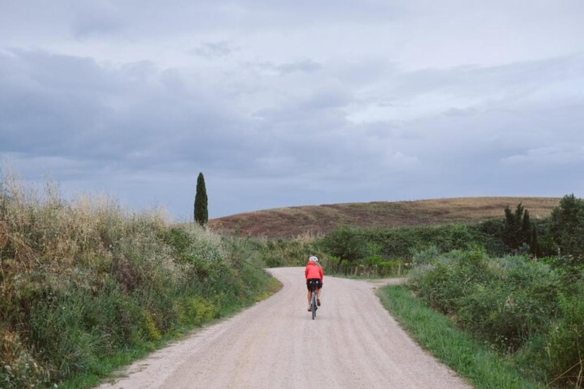 una persona che va in bicicletta lungo una strada sterrata