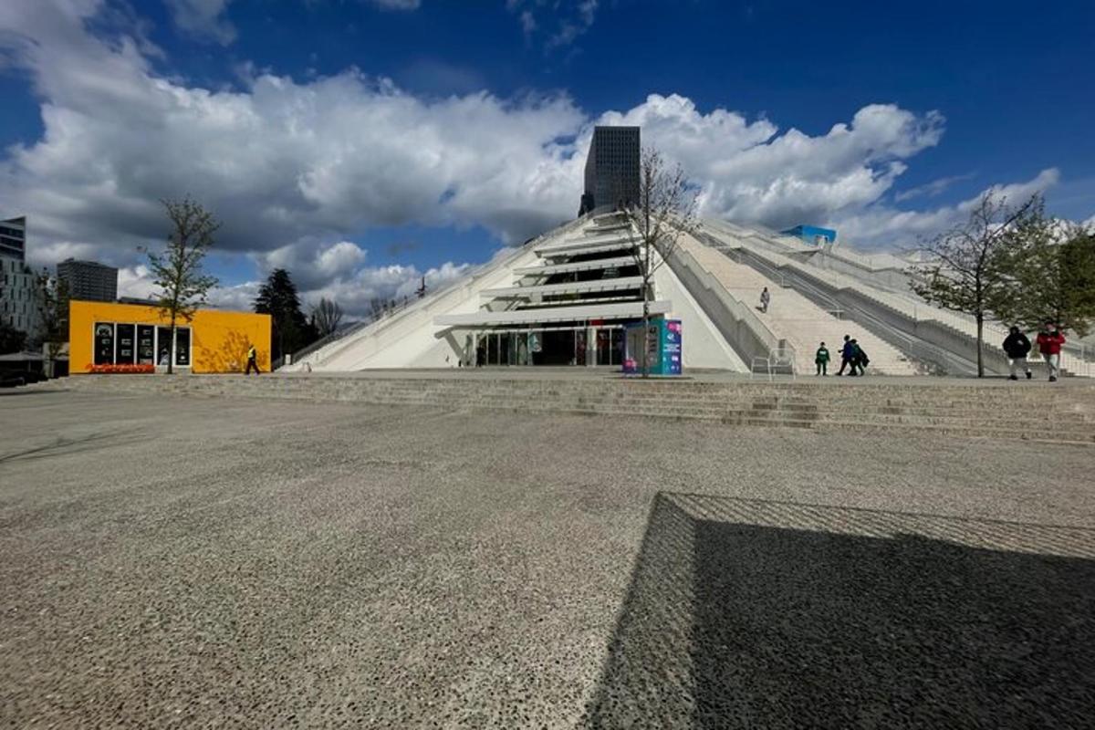a large pyramidangular building with people walking around it