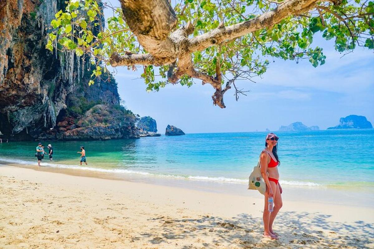 seorang wanita berdiri di pantai berhampiran air