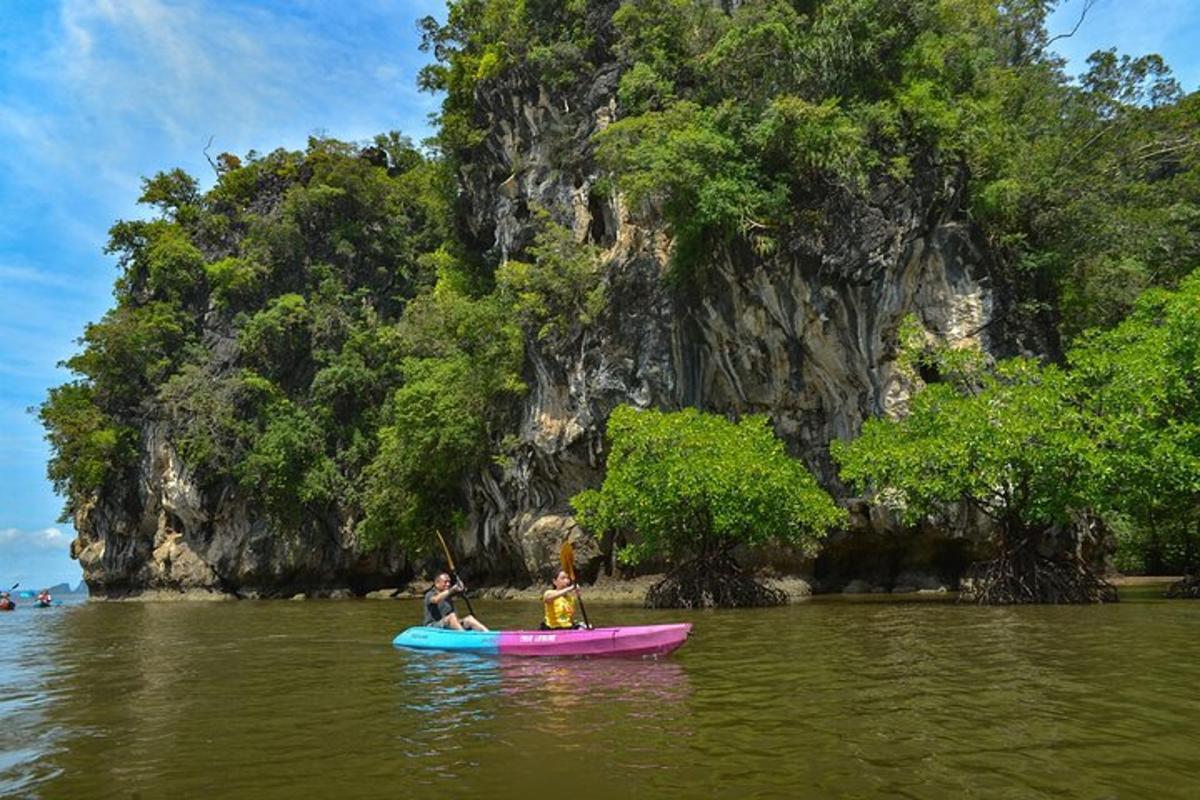 due persone su un kayak in acqua vicino a una montagna