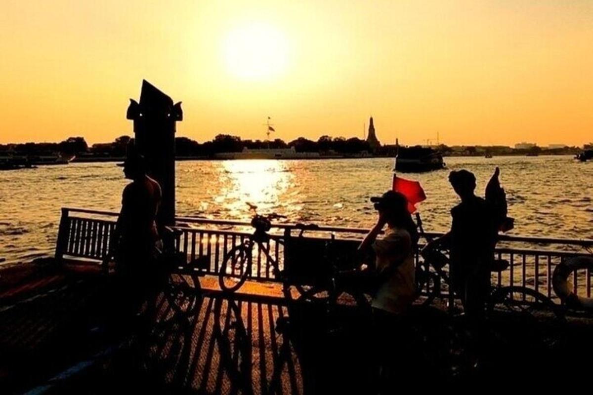 một nhóm người đang ngồi trên hàng rào gần mặt nước