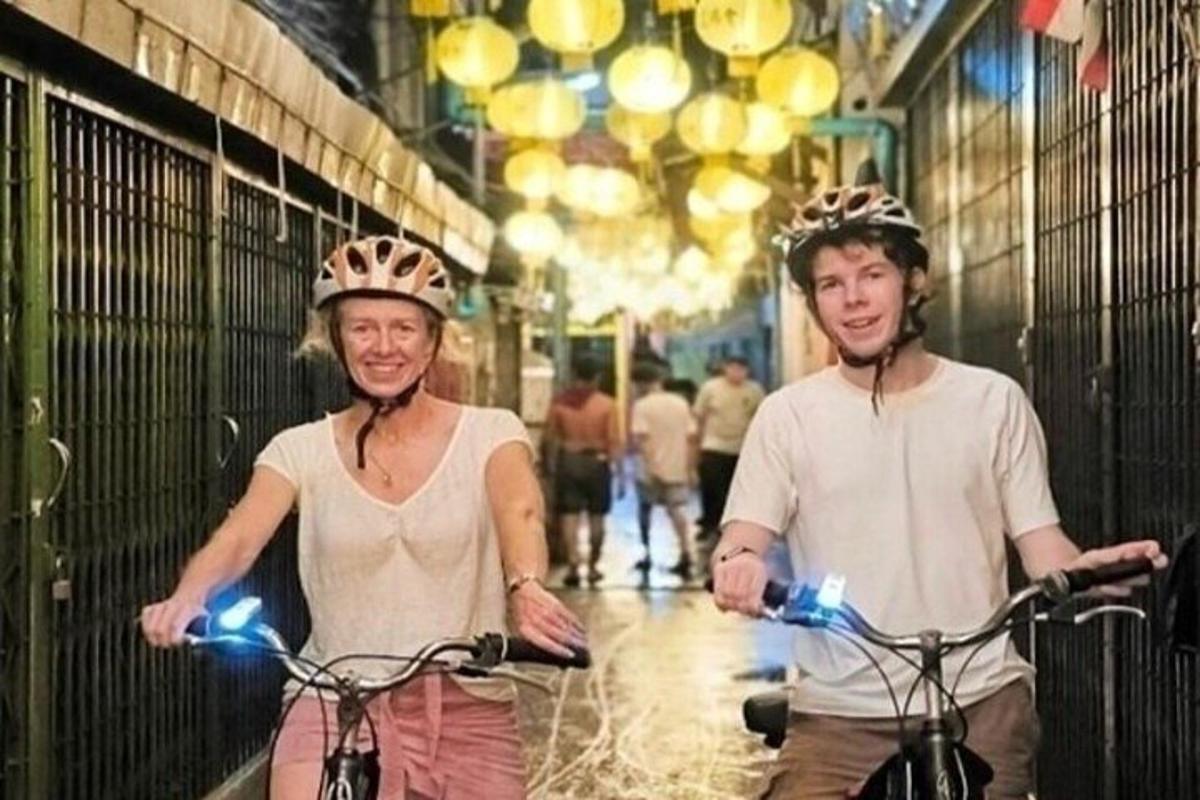 dvaja ľudia v prilbách jazdia na bicykloch po ulici