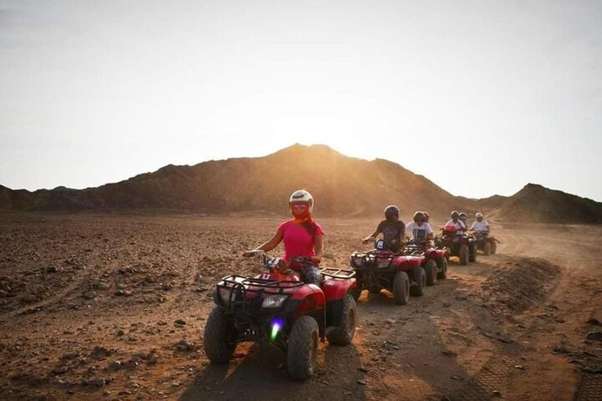 um grupo de pessoas andando de quadriciclo em uma estrada de terra