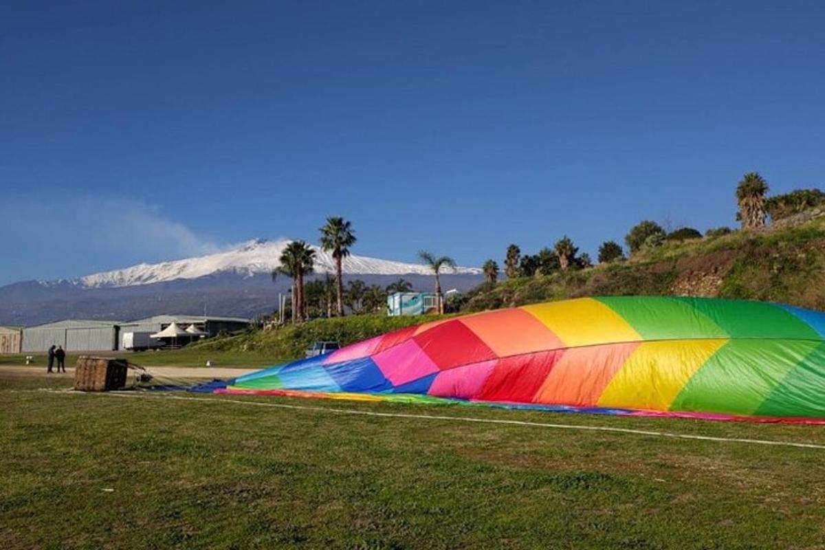一只彩虹色的风筝躺在田野的草地上