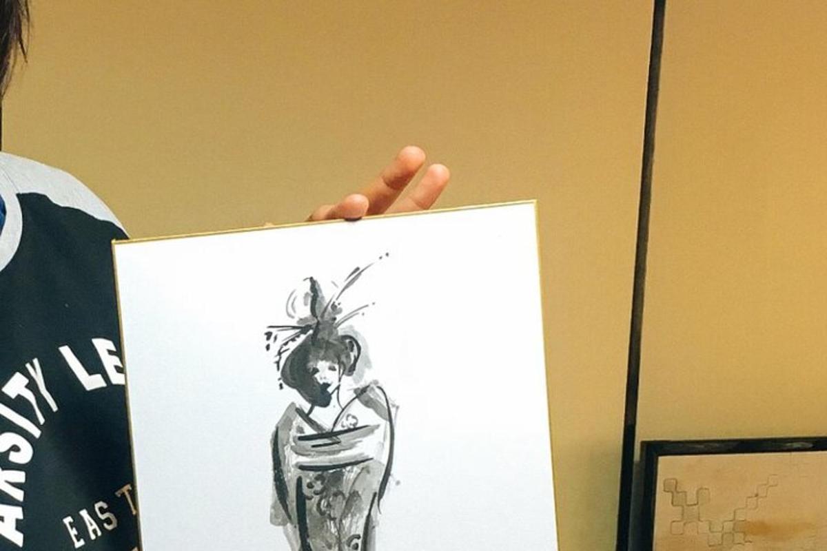 ένα άτομο που κρατάει ψηλά ένα σχέδιο μιας γυναίκας