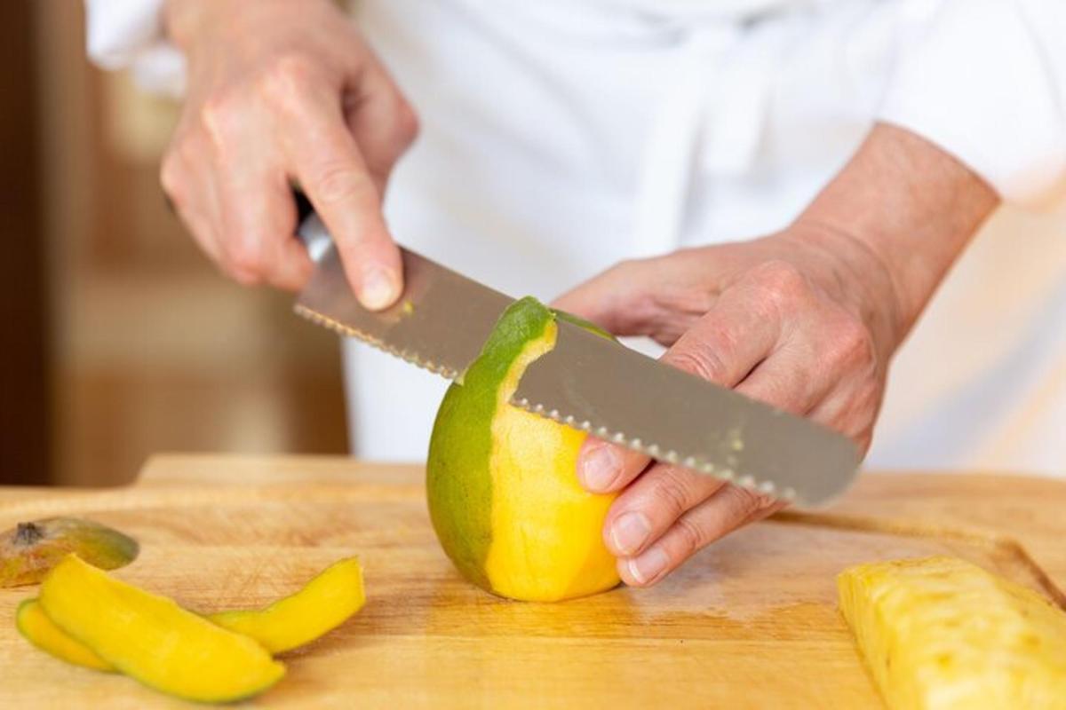 osoba krájející citron nožem na prkénku