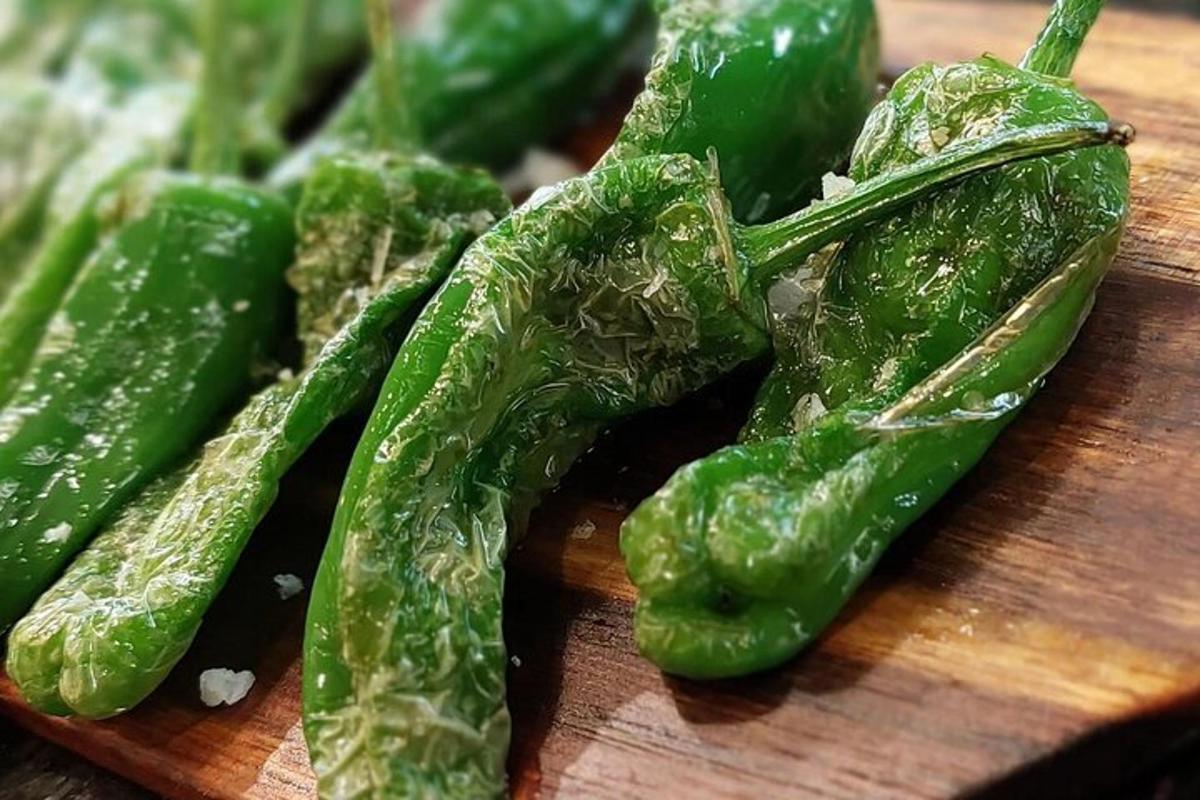 skupina zelenih paprik na leseni deski za rezanje