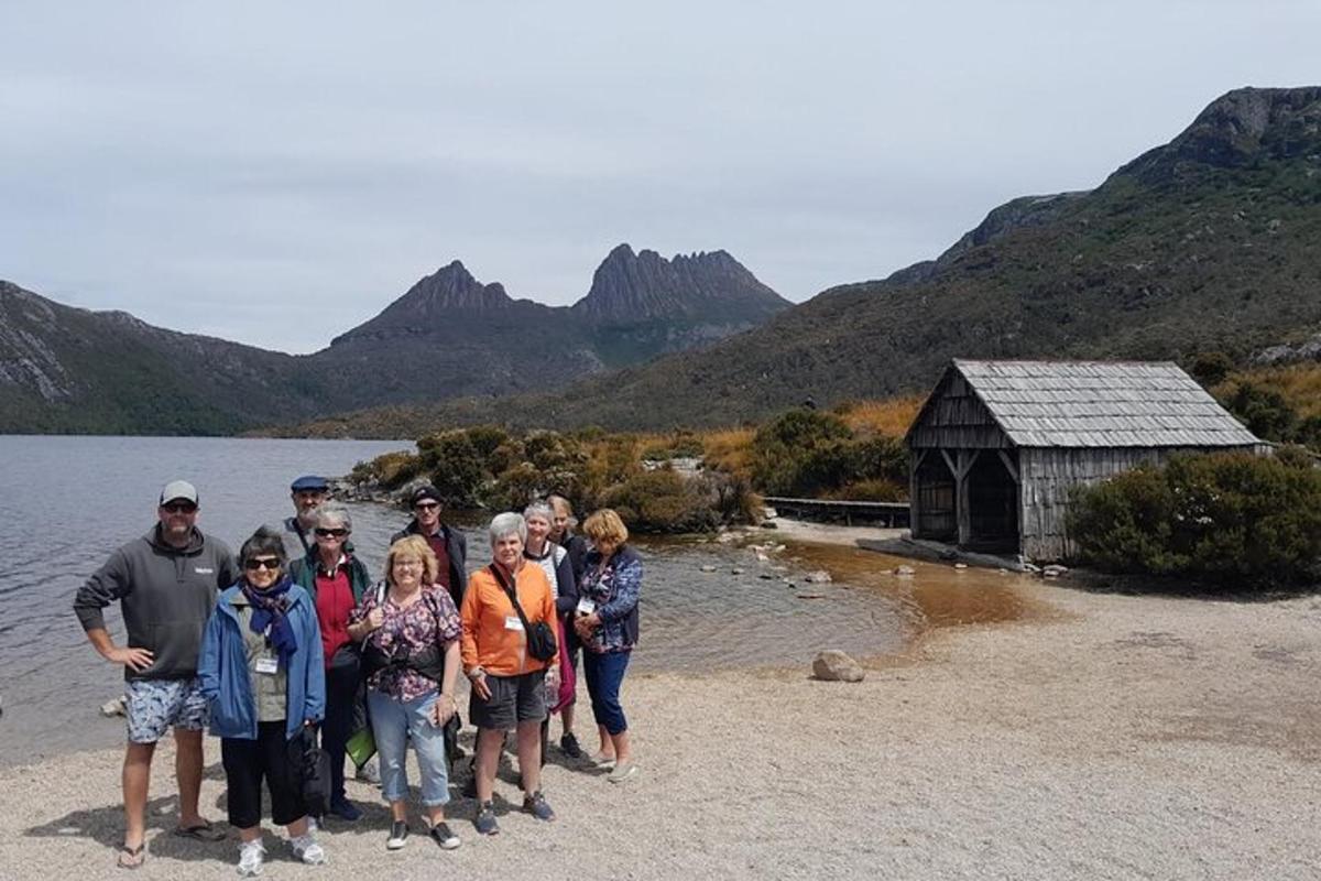 a group of people standing on the shore of a lake
