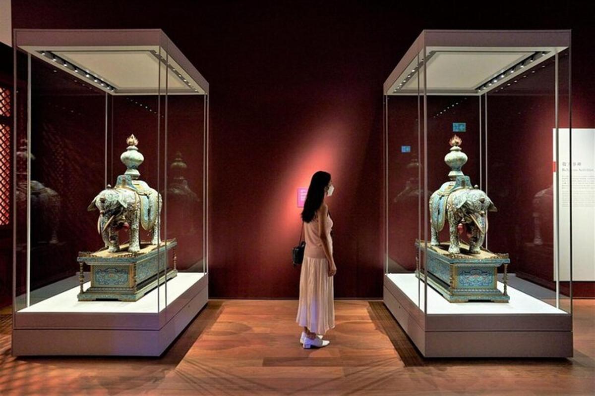 a woman standing in front of two display cases in a museum