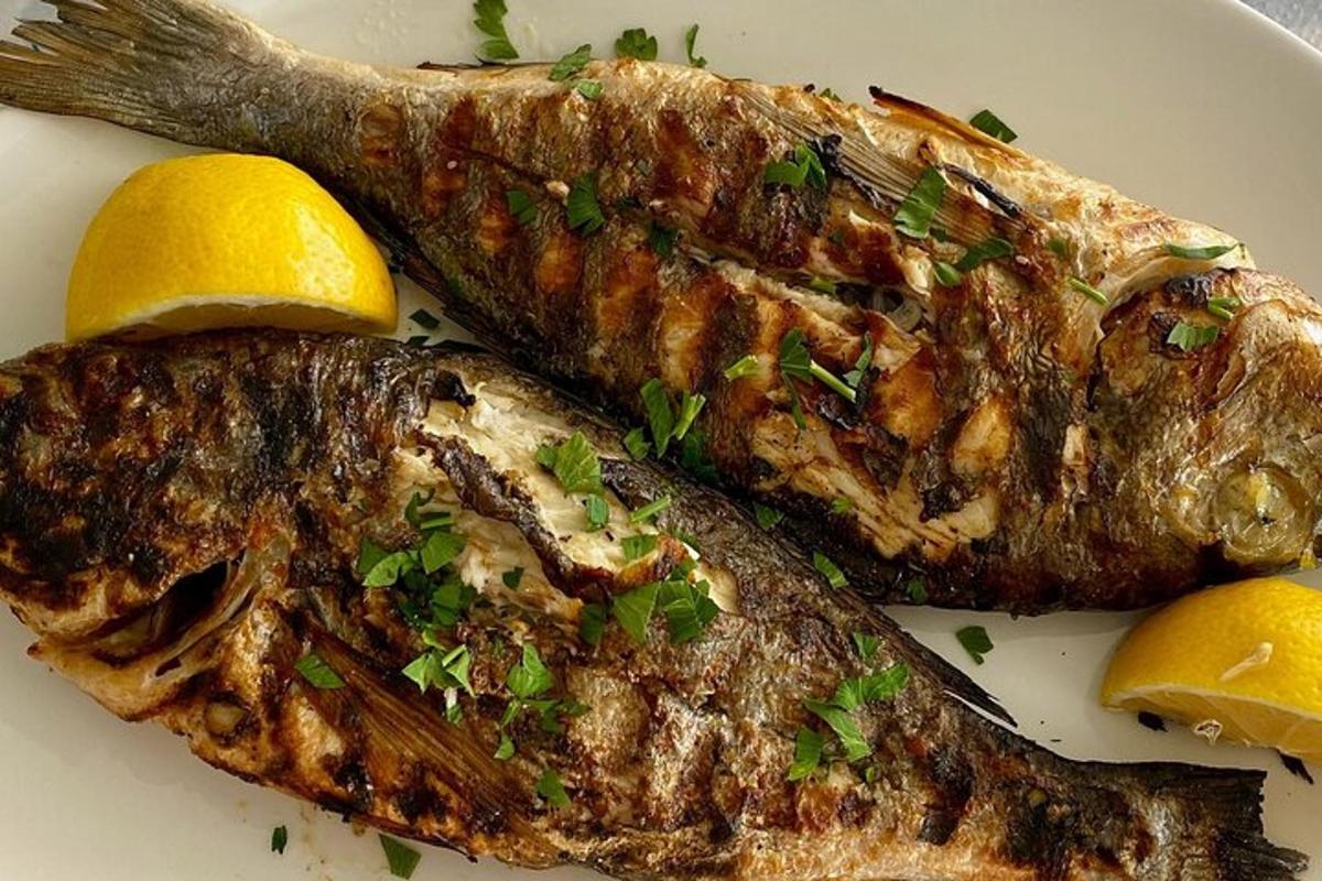 une assiette de nourriture avec du poisson et des citrons dessus