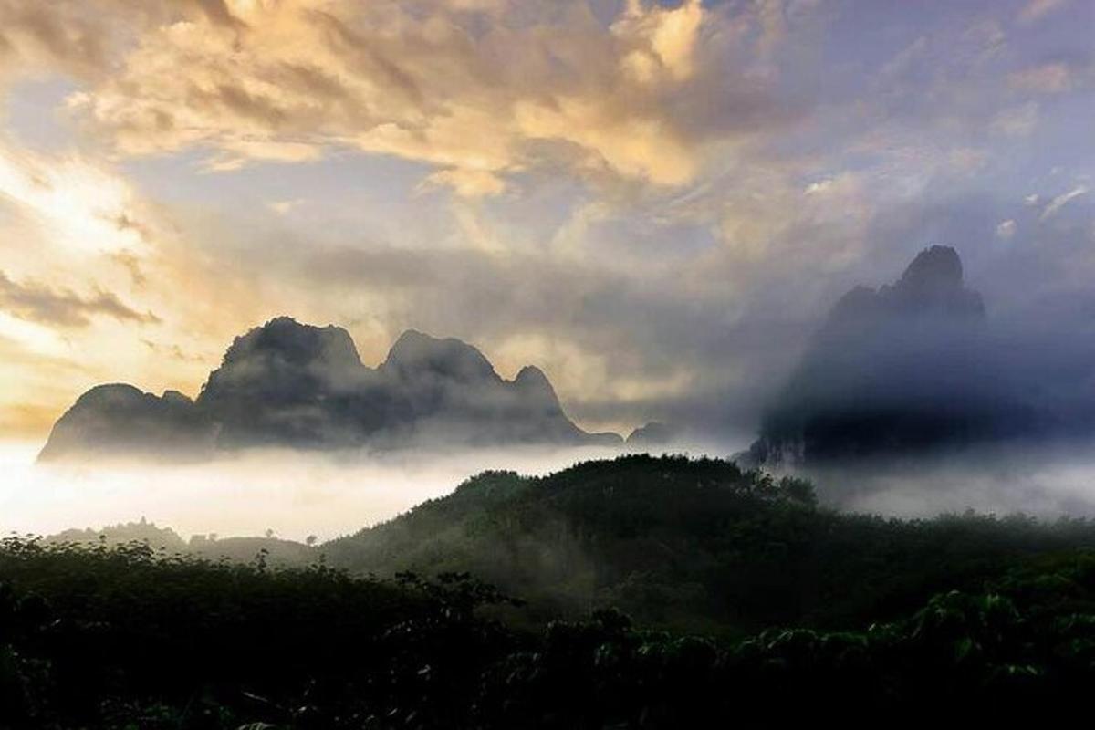 um vale enevoado com montanhas e nuvens no céu